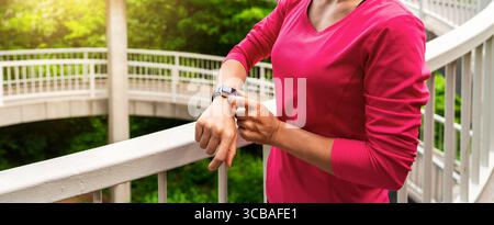 Fitte Sportlerin, die beim Training im Freien den Smart Watch Fitness-Tracker ansieht Stockfoto
