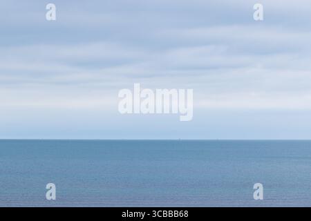 Friedliche Meereslandschaft mit ruhigem Meer und einem Himmel voller flauschiger weißer Wolken, die ein entspannendes und ruhiges Küstenambiente bieten. Kaspisches Meer, Buz Stockfoto