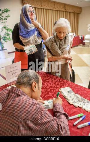22. Oktober 2016: Eine Besucherin einer Moschee in Anahem, CA, hat ihren Namen in Arabisch geschrieben, bevor sie einen Hijab trägt, oder den traditionellen islamischen weiblichen Kopfschal. Beachten Sie den Besucher auf der linken Seite mit Schal. (Kreditbild: © Spencer Grant/ZUMA Press Wire) Stockfoto