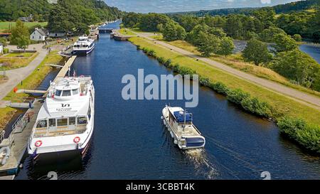 Jacobite Loch Ness Cruises Dochgarroch Caledonian Canal Schottland zwei vertäute Boote und ein kleines Boot, das auf die Schleuse zusteuert Stockfoto