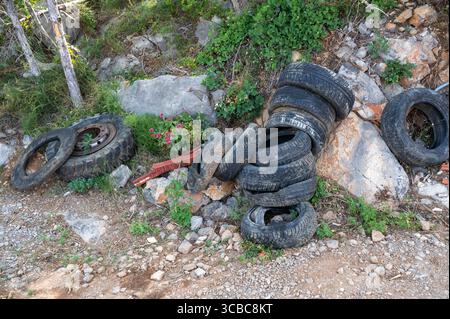 Alte Autoreifen liegen in der Natur am Straßenrand Stockfoto