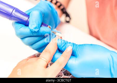 Maniküre. Der Manikürenmeister poliert den Nagel mit einer Maschine. Schließen Sie die Maniküre. Stockfoto