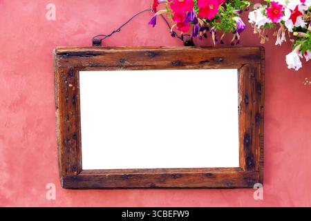 Vintage alter Retro-Holzrahmen auf rosa roter Wand mit Blumen. Design-Modell. Stockfoto