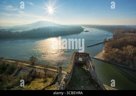 Aus der Vogelperspektive der antiken Burgruine treffen auf den fließenden Fluss, eingerahmt von der Landschaft unter dem strahlenden Licht der Sonne, Devin, Region Bratislava, Slowakei. Stockfoto