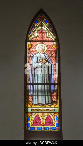 Vietnam, Hanoi. Die St. Joseph's Cathedral ist eine katholische Kirche im Bezirk Hoàn Kim in Hanoi. Es handelt sich um eine neugotische Kirche aus dem späten 19. Jahrhundert, die als Kathedrale der römisch-katholischen Erzdiözese Hanoi dient. Die Kathedrale ist nach Joseph, dem Schutzpatron Vietnams, benannt. Buntglasfenster mit dem Bild des Heiligen Johannes Baptist de la Salle. Stockfoto