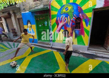 20. November 2022, Kolkata, Westbengalen, Indien: Mitglieder des Dishari-Clubs Uttar Kolkata spielen und spielen Fußballtricks vor einer Wand, die mit Graffitti-Künsten geschmückt ist, um die Weltmeisterschaft 2022 zu feiern. (Bild: © Debarchan Chatterjee/ZUMA Press Wire) Stockfoto