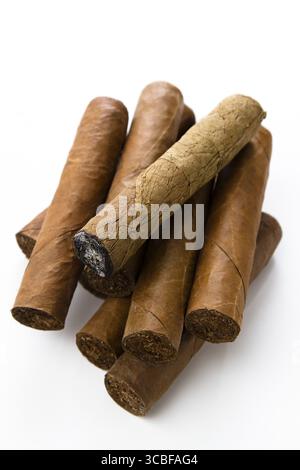 Kubanische Zigarren stapeln eine übereinander, mit einer ungewickelten geräucherten Zigarre darüber Stockfoto