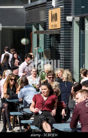 Stadtarbeiter und Freunde genießen ein Mittagessen in einem Café im Freien in Liverpool an einem sonnigen Tag und halten den lebendigen urbanen Lebensstil und die Kultur des Cafés fest. Stockfoto