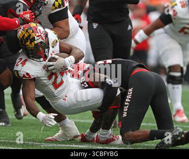 30. Dezember 2022, Charlotte, North Carolina, Vereinigte Staaten von Amerika: 30. Dezember 2022: Maryland Terrapins Running Back Roman Hemby (24) wird vom North Carolina State Wolfpack Cornerback Shyheim Battle (25) während des NCAA Football Dukeâ Bowl zwischen den North Carolina State Wolfpack und den Maryland Terrapins im Bank of America Stadium in Charlotte, North Carolina, niedergeschlagen. Wes Hight/Zuma Press (Foto: © Wes Hight/ZUMA Press Wire) Stockfoto