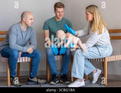 Erste-Hilfe-Ausbilderin demonstriert die Technik der Blockade beim Ersticken von Säuglingen durch Rückstöße an einer Basic Life Support ( Stockfoto