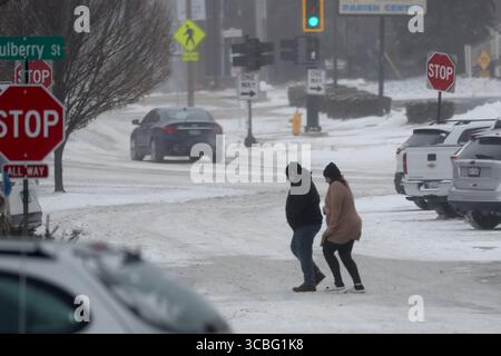 23. Dezember 2022, McLean County, Illinois, USA: Fußgänger kämpfen gegen den Wind, um die Straße in Downtown Bloomington zu überqueren. Der Wintersturm Elliott wehte am 22. Dezember durch McLean County Illinois und ließ wenig Schnee fallen, brachte aber extreme Kälte und starke Winde mit sich, die an manchen Stellen fast verdunkelten. Das Timing war weniger als wünschenswert für die Bewohner, die nach einem weißen Weihnachten suchten, aber nicht die Schwierigkeiten, die Kälte und Wind bringen. (Kreditbild: © Alan Look/ZUMA Press Wire) Stockfoto
