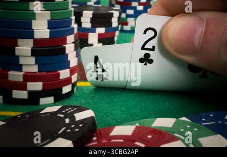 Nahaufnahme Eines Anonymen Pokerspielers, Der Spielkarten Überprüft. Professioneller High Stakes Spieler, der Eine Wette macht, denkt an Stockfoto