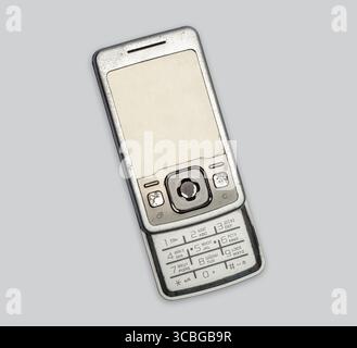 Altes Klapptelefon mit Knöpfen auf grauem Hintergrund, isoliert. Altes Mobiltelefon benutzt. Konzept der Verwendung und des Recyclings von Elektronikschrott. Alte Gadgets. Stockfoto