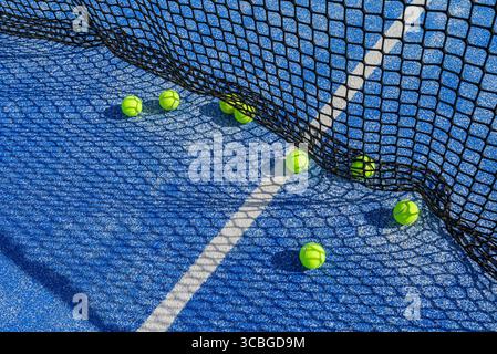 Hochwinkelansicht von auf einem blauen Platz verstreuten Padelbällen nach Trainingskonzept Stockfoto