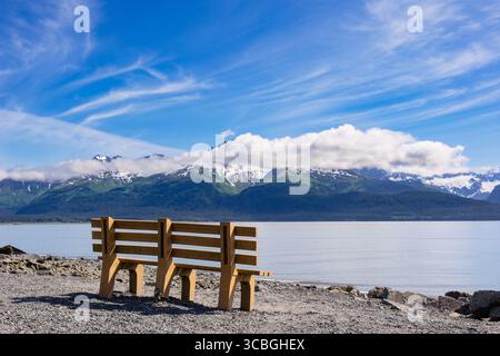 Leere Sitzbank am Meer mit Blick auf den Mount Alice und den Godwin-Gletscher über die Resurrection Bay an der Südküste Alaskas. Seward, Alaska Stockfoto