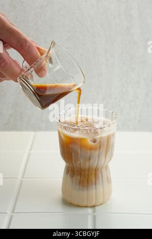 Espresso in Eiskaffee geben Stockfoto