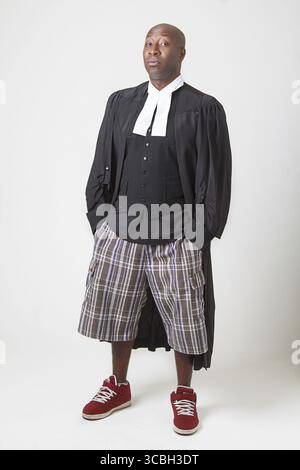 afroamerikanische Glatzen tragen Shorts und Sneaker mit einem Anwalt Toga Stockfoto