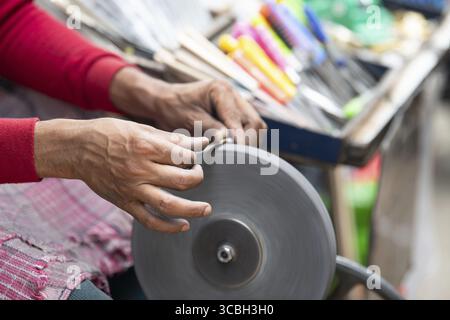 Schärfen der Messer Klinge auf einem Schleifstein, indischer Messerschärfer im Einsatz, Rad über Pedale angetrieben, Kultur Indiens Stockfoto