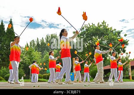 Peking, Chinas Provinz Shandong. August 2025. Die Menschen trainieren an einem Platz am Fluss im Bezirk Fushan der Stadt Yantai, der ostchinesischen Provinz Shandong, 8. August 2025. Da das Land diesen Freitag den nationalen Fitness-Tag begeht, ein Erbe der Olympischen Spiele 2008 in Peking, nehmen immer mehr Menschen einen aktiven Lebensstil auf. Quelle: Sun Wentan/Xinhua/Alamy Live News Stockfoto