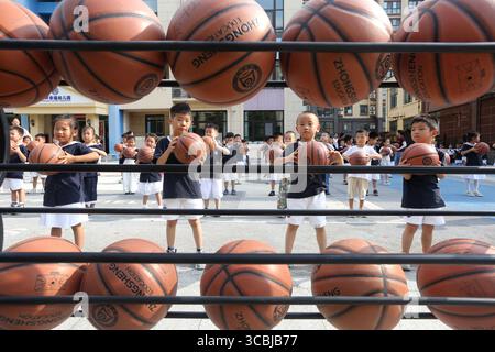 Peking, Chinas Provinz Jiangsu. August 2025. Kinder üben Freistil-Basketball in einem Kindergarten in Lianyungang, ostchinesischer Provinz Jiangsu, 8. August 2025. Da das Land diesen Freitag den nationalen Fitness-Tag begeht, ein Erbe der Olympischen Spiele 2008 in Peking, nehmen immer mehr Menschen einen aktiven Lebensstil auf. Quelle: Wang Chun/Xinhua/Alamy Live News Stockfoto