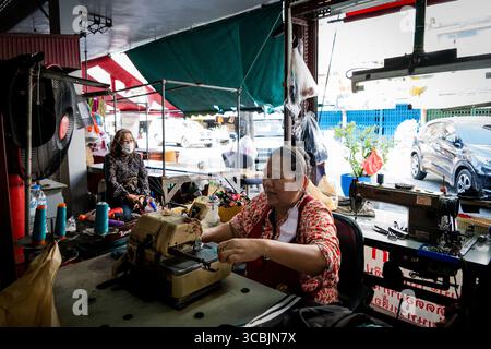 10. Februar 2023 in Bangkok, Bangkok, Thailand: Eine Schneiderin arbeitet an ihrer Nähmaschinenstation in einem Außenmarkt in Bangkok. (Kreditbild: © Matt Hunt/ZUMA Press Wire) Stockfoto