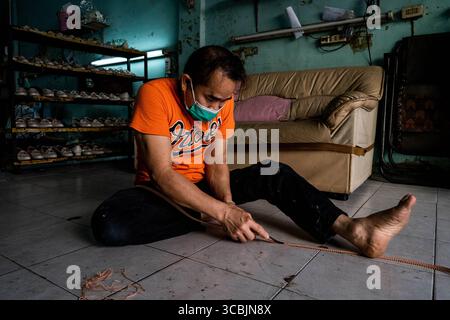 10. Februar 2023, Bangkok, Thailand: Ein Arbeiter trimmt Leder, während er Schuhe in einem Sweatshop in Ost-Bangkok herstellt. (Kreditbild: © Matt Hunt/ZUMA Press Wire) Stockfoto