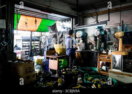 10. Februar 2023 in Bangkok, Bangkok, Thailand: Ein Arbeiter, der zwischen Schuhen steht, wird in einem Sweatshop in Ost-Bangkok beim Nähen gesehen. (Kreditbild: © Matt Hunt/ZUMA Press Wire) Stockfoto