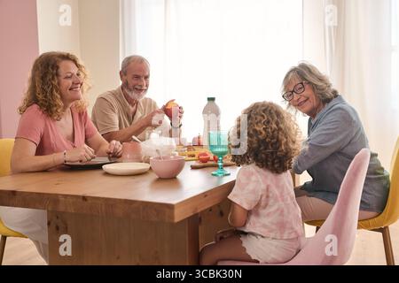 Glückliche Familie, die zu Hause das gemeinsame Frühstück genießt Stockfoto
