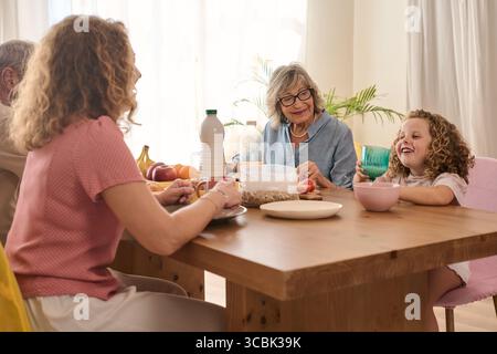 Glückliche Familie, die zu Hause das gemeinsame Frühstück genießt Stockfoto