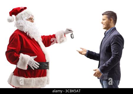 Profilaufnahme des weihnachtsmanns, der einem jungen Mann einen Autoschlüssel gibt, isoliert auf weißem Hintergrund Stockfoto