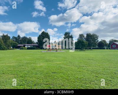 Ein schöner sonniger Tag im Park mit einem Spielplatz und grünem Gras. Stockfoto
