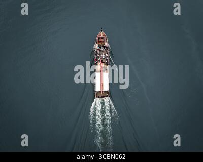 Aus der Vogelperspektive eines Bootes, das durch das dunkle Wasser segelt und einen schaumigen Pfad hinterlässt, Kawaguchi Lake, Yamanashi, Japan. Stockfoto