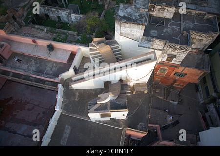 Aus der Vogelperspektive auf die komplizierte, gestufte Architektur, die das goldene Licht der untergehenden Sonne über der antiken Stadt Varanasi, Uttar Pradesh, Indien reflektiert. Stockfoto
