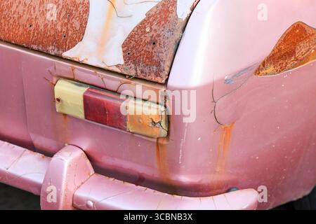 Die Rücklichter eines verlassenen alten, rostigen Autos am Straßenrand. Stockfoto
