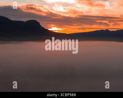 Sonnenuntergang über den Nebelbergen in Islands zerklüfteter Landschaft Stockfoto