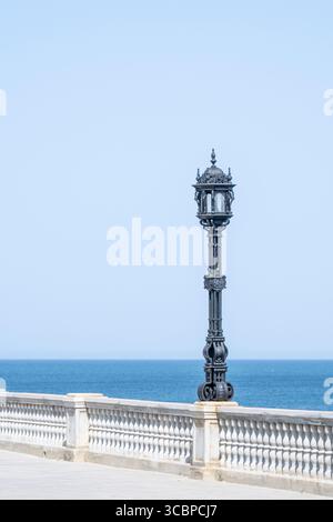 Verzierte schwarze Laternenpfahl entlang der Strandpromenade in Cádiz, Spanien, Stockfoto
