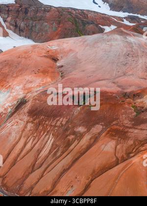 Vogelperspektive auf Islands Regenbogenberge mit Schneepfaden Stockfoto