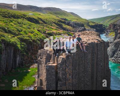 Die Leute saßen auf Basalt Columns im Studlagil Canyon, Island Stockfoto