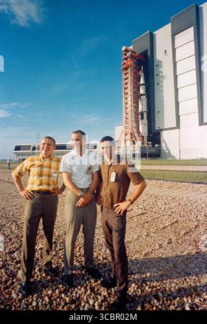 Auf diesem Handout-Foto der US-Regierung, das am 8,1968. Oktober aufgenommen wurde, steht die Apollo 8 Prime Crew im Vordergrund, als das Raumfahrzeug Apollo (Raumschiff 103/Saturn 503) das Fahrzeugbauhaus des Kennedy Space Centers auf dem Weg zum Startplatz A, Launch Complex 39 verlässt. Der Saturn V-Stapel und sein mobiler Startturm befinden sich auf einem riesigen Raupentransporter. Die Apollo-8-Besatzung besteht aus (von links nach rechts) Astronauten Frank Borman, Kommandant, James A. Lovell Jr., Pilot des Kommandomoduls, und William A. anders, Pilot des Mondmoduls. Im August 1968 erhielten diese drei NASA-Astronauten einen Anruf, der sie aufforderte, die NASA-Astronauten abzubrechen Stockfoto