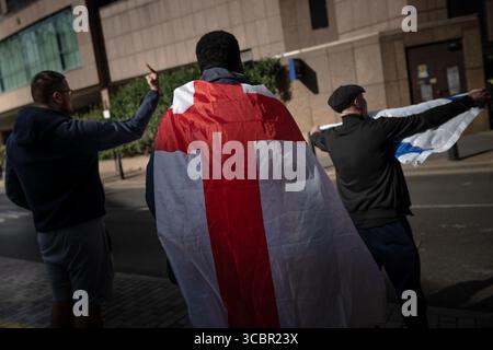 London, Großbritannien. August 2025. Migrantenfeindliche Demonstranten demonstrieren vor dem Britannia International Hotel in Canary Wharf, in dem derzeit Asylsuchende untergebracht sind. Während der Demonstration am Freitagabend wurden zwei Personen verhaftet, wobei Offiziere rivalisierende Gruppen trennten. Mehr als 100 Menschen protestierten gegen Rassismus. Guy Corbishley/Alamy Live News Stockfoto