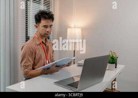 Ein Geschäftsmann ist im Büro, er arbeitet in einem modernen Büro, der Marketingleiter arbeitet mit vielen Dokumenten, der Finanzmanager arbeitet seitdem Stockfoto