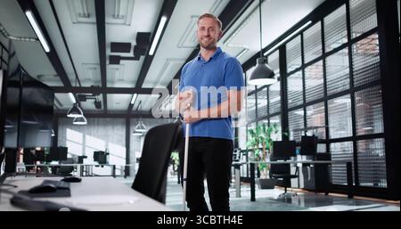 Happy Professional Office Cleaner posiert neben dem Schreibtisch nach Einem langen Tag. Stockfoto