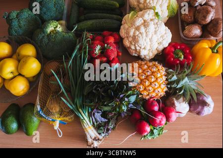 Eine Reihe verschiedener Lebensmittel, die vom lokalen Markt mitgebracht und auf einer Holzoberfläche angeordnet werden Stockfoto