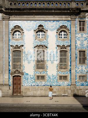 Frau mit Blick auf die blaue Azulejos-Fassade von Igreja do Carmo, Porto Reiseattraktion Stockfoto
