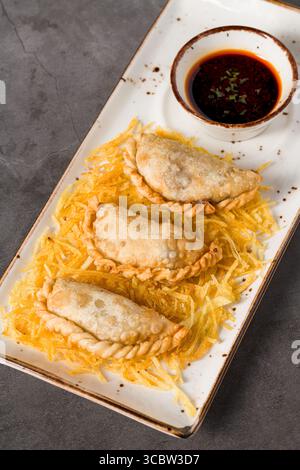 Knusprige Fleischknödel serviert auf geriebenen Kartoffeln mit Sojasauce Stockfoto