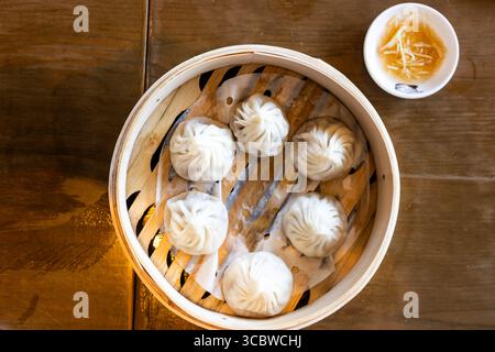 Shanghai beliebte Xiaolongbao oder kleine Drachenknödel, gedämpft und in Bambuskorb serviert. Stockfoto