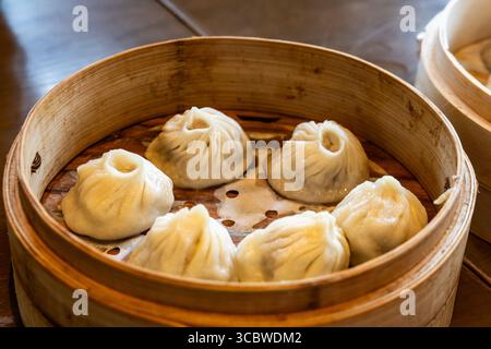 Shanghai beliebte Xiaolongbao oder kleine Drachenknödel, gedämpft und in Bambuskorb serviert. Stockfoto