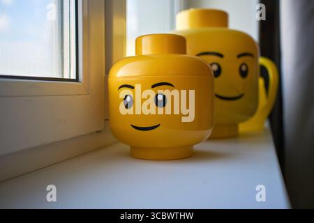 Tyumen, Russland-8. Juli 2025: Bunte Container, die Lego-förmig sind, ruhen auf einer Fensterbank Stockfoto