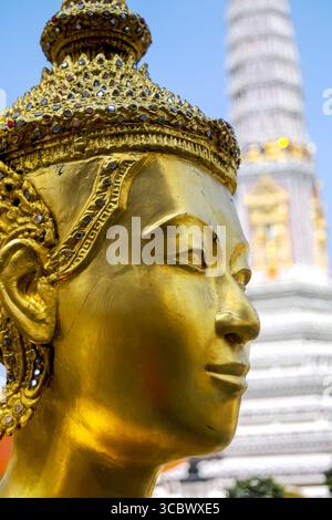 Aus nächster Nähe den Kopf Buddhas im Großen Palast von Bangkok, mit heiterem Ausdruck, goldenen Details und komplizierter Handwerkskunst, die thailändisches Handwerk widerspiegelt. Stockfoto
