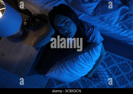 Frustrierte Frau mit Kissen, die an Schlaflosigkeit litt, auf dem Boden zu Hause, Blick von oben Stockfoto